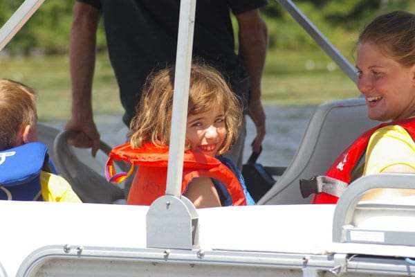 Child on a pontoon smiling.