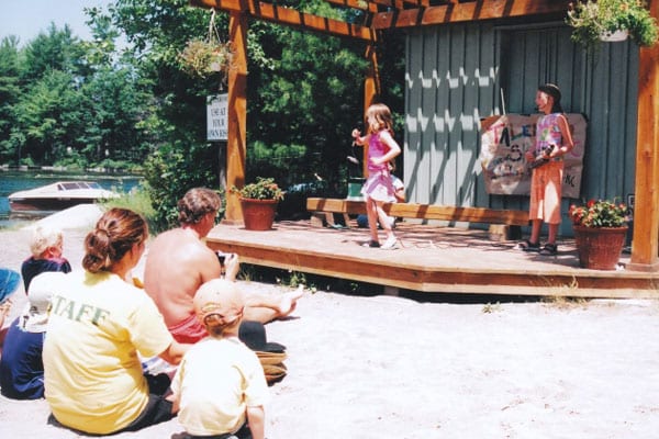 Young girls performing on a beach side stage.