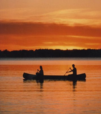 Two people canoing at sunset.