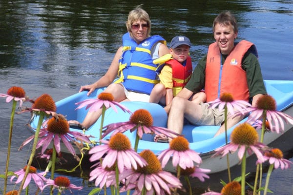 Parents and son in a paddleboat.