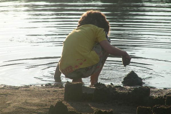 Young boy making sand castles.