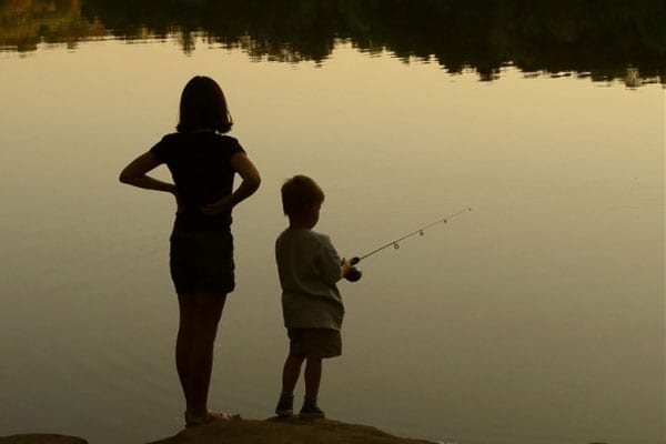 Boy and girl fishing at sunset.