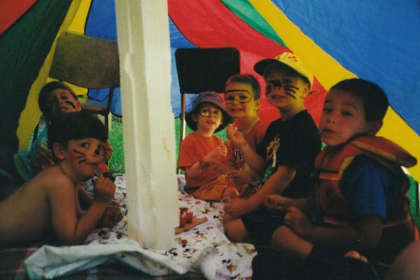 Kids with facepaint in a tent.