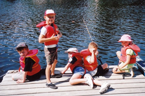 Young kids fishing on the dock.