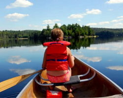 Girl sitting in a canoe overlooking Stoney Lake