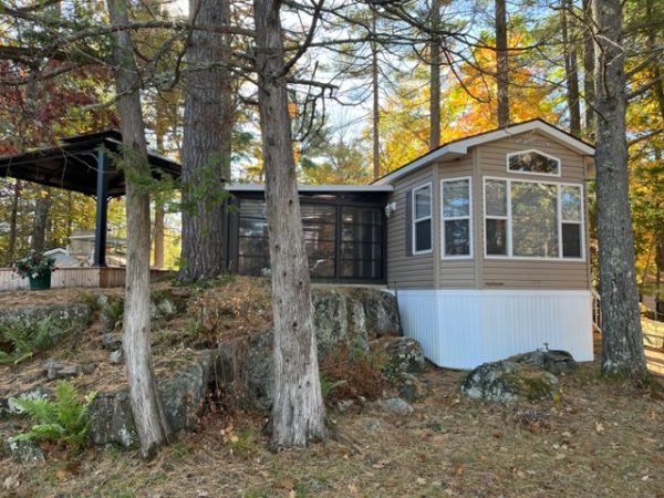 A cabin in the woods with a wide bay of windows