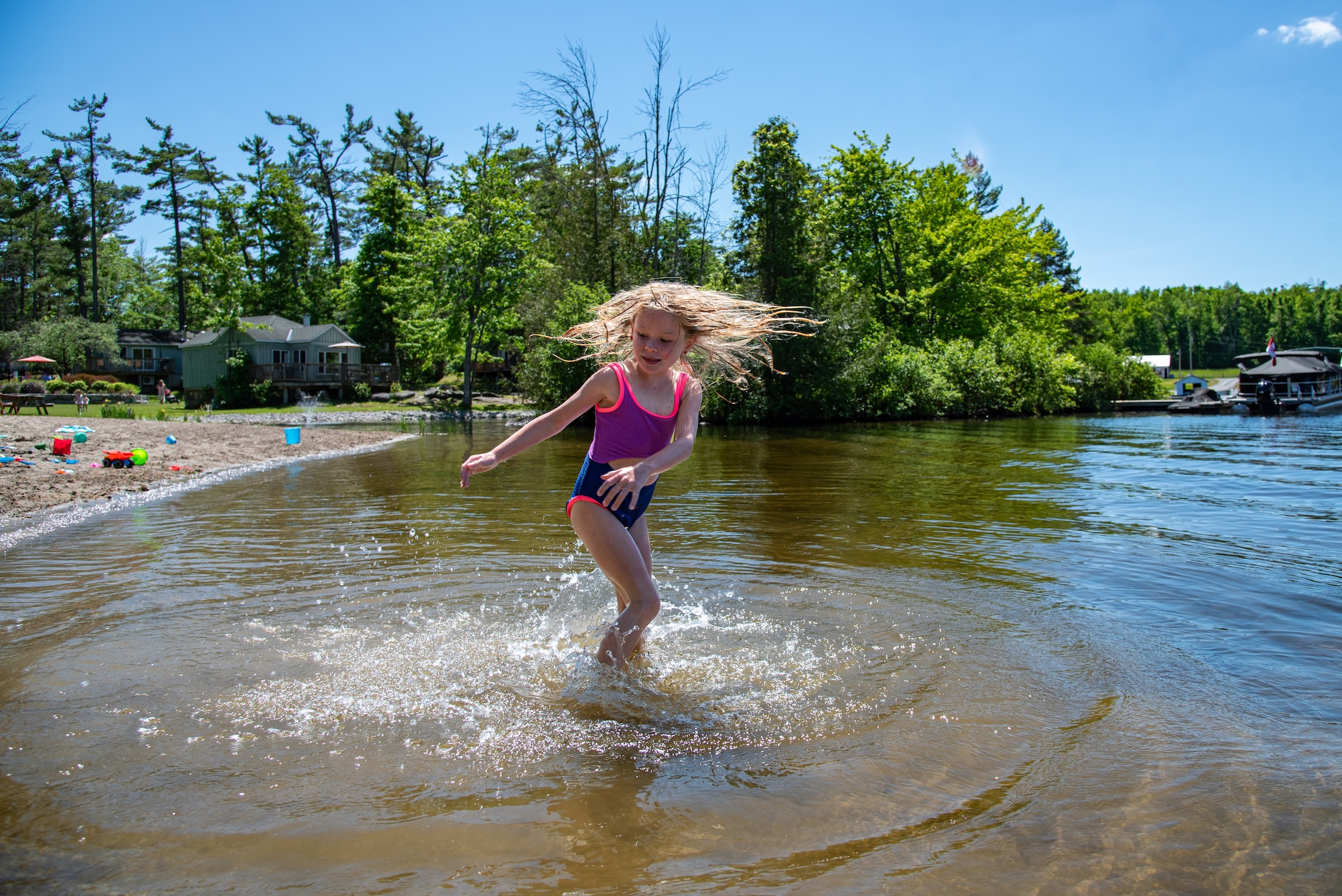 A girl playing at the beach whips her hair around